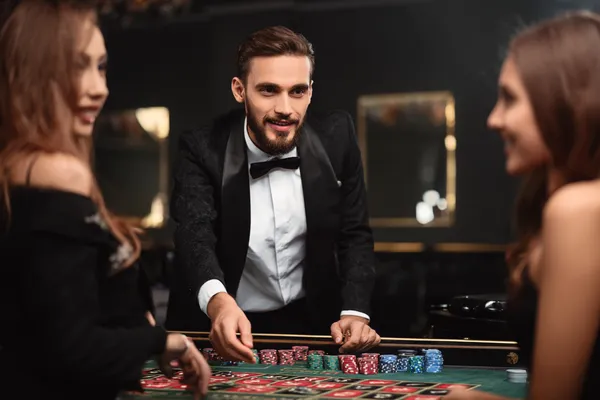 Uma mulher sorrindo enquanto joga online em seu laptop, cercada por elementos de cassino em néon, destacando a coleção diversificada de jogos do 777AN.